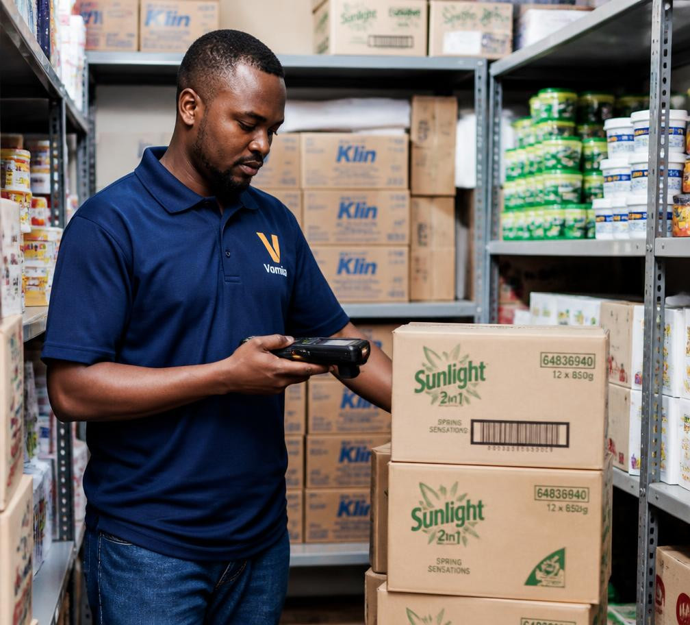 Staff member scanning cartons with a handheld barcode scanner in a stockroom